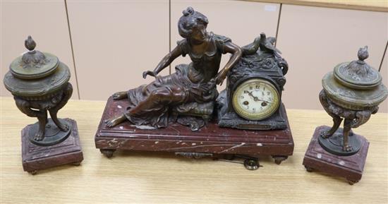 An early 20th century spelter clock garniture, on rouge marble plinths, clock width 44cm